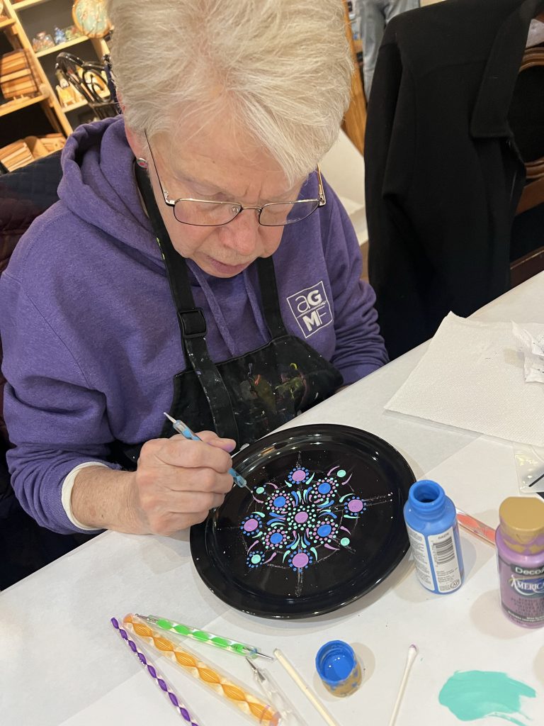 Photo of Art Guild member Mary participating in The Dotting Chick's workshop during the March member meeting.